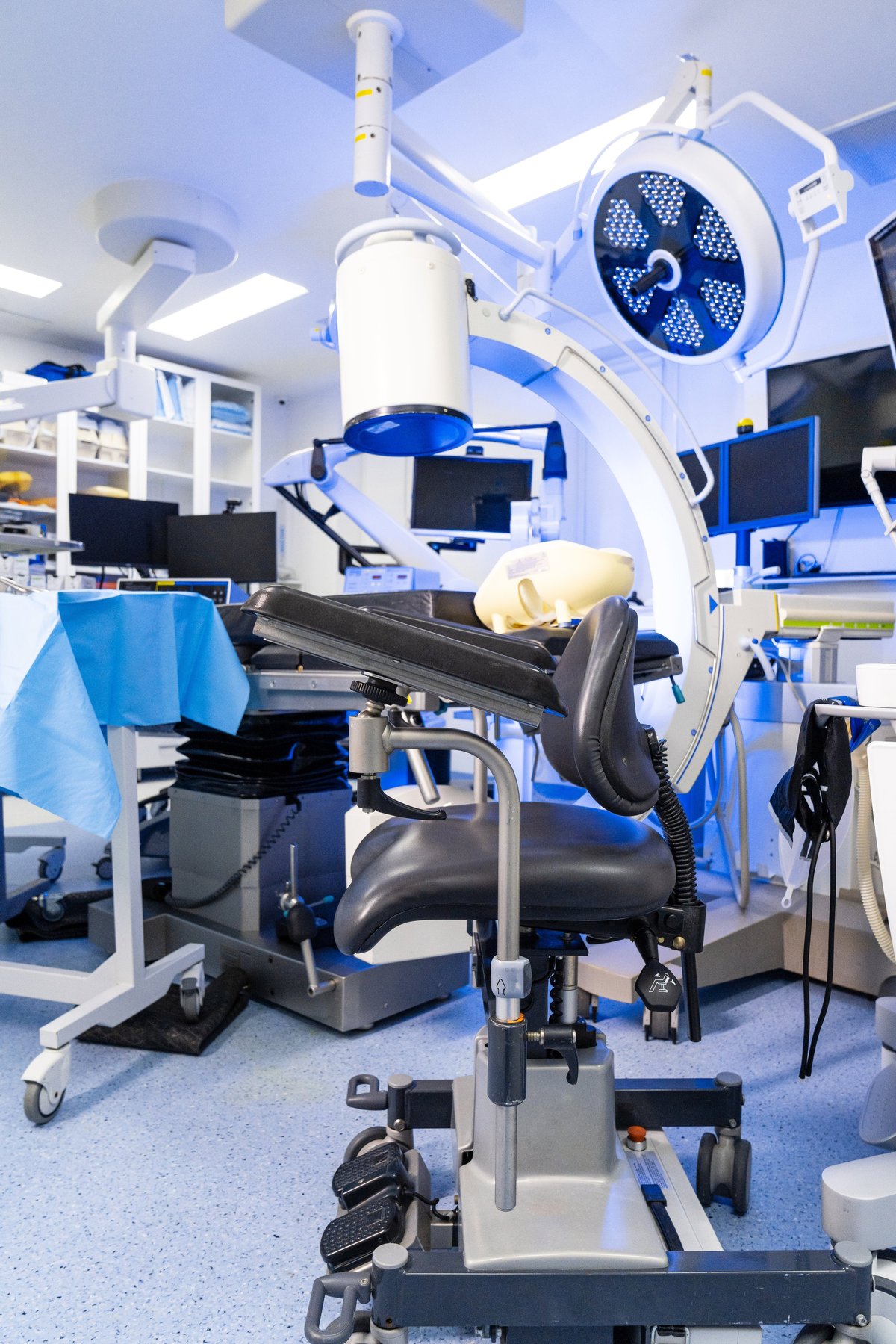 Mobile C-arm x-ray machine and surgical chair in operating room